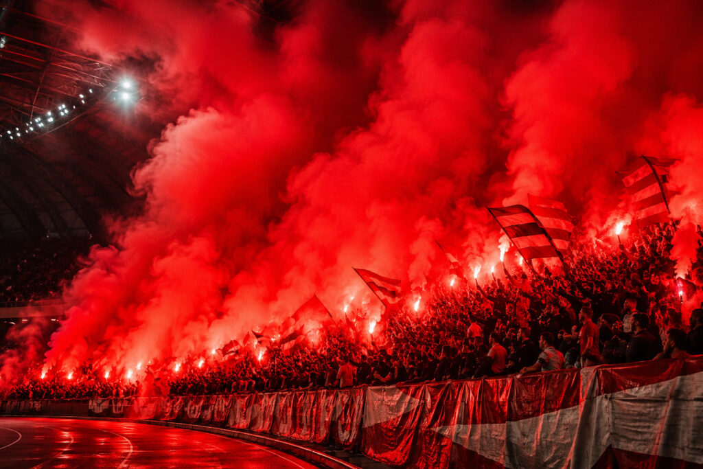 Intensywny czerwony dym podczas oprawy stadionowej przygotowanej przez kibiców