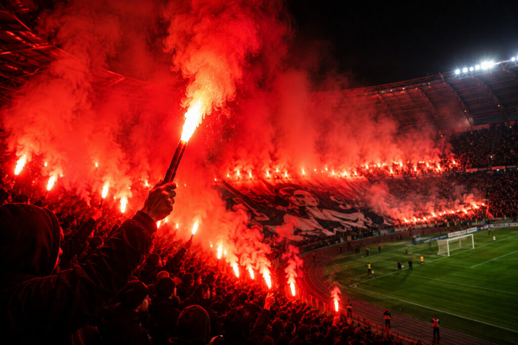 Oprawa meczowa z wykorzystaniem rac na stadionie piłkarskim